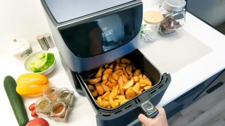 A person displays a bag of chips in front of an air fryer safe cookware, hinting at snack prep.